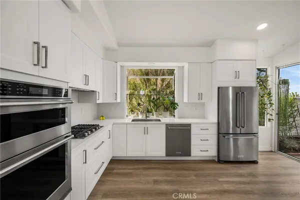 a kitchen with stainless steel appliances a stove a refrigerator and a dining table