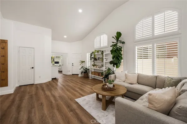 a living room with furniture a flat screen tv and a potted plant