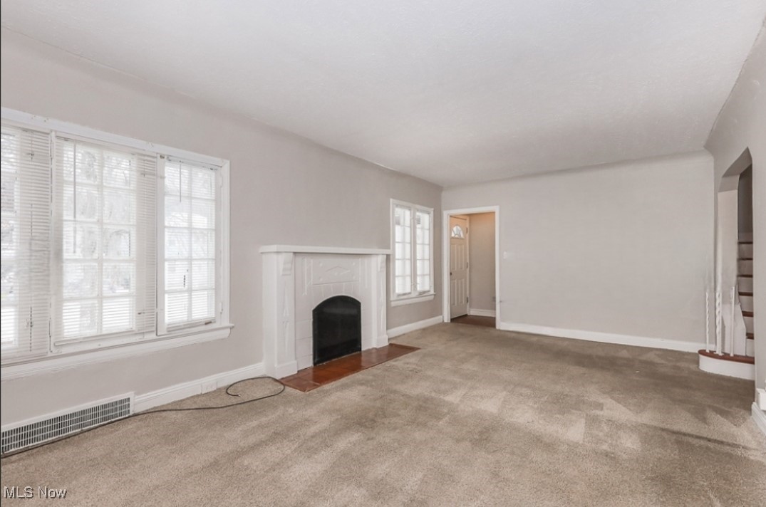 3649 Cummings Road Cleveland, OH 44118 - Photo 4 of 11 Unfurnished living room featuring carpet and a tiled fireplace
