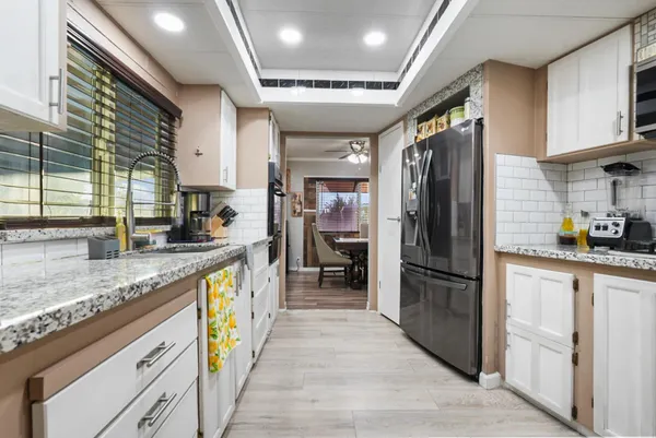 a open kitchen with stainless steel appliances granite countertop a refrigerator stove sink and cabinets