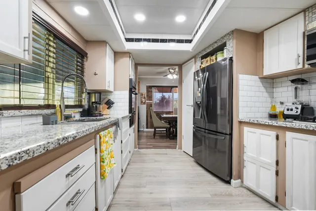 a open kitchen with stainless steel appliances granite countertop a refrigerator stove sink and cabinets