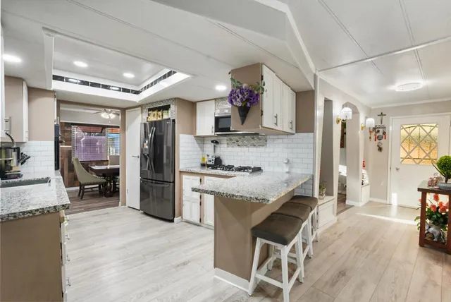 a kitchen with kitchen island granite countertop a sink cabinets and refrigerator