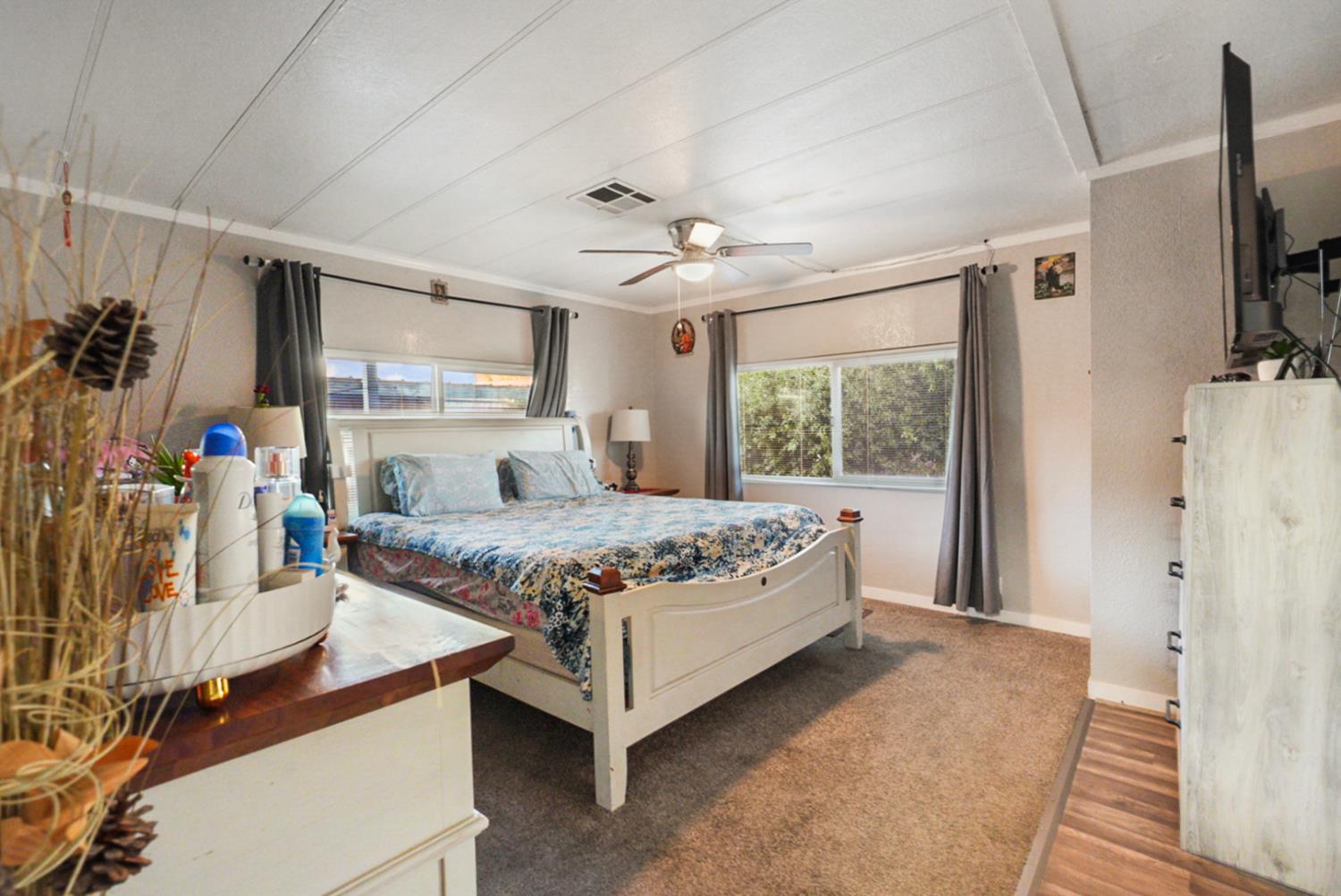 4837 Faith Home Road, Unit 162 Ceres, CA 95307 - Photo 24 of 45 a bedroom with a bed flat screen tv and a large window