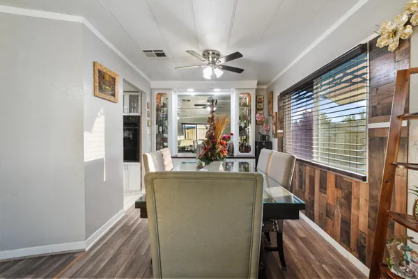 a kitchen with stainless steel appliances granite countertop a refrigerator a microwave oven a sink dishwasher and white cabinets with wooden floor