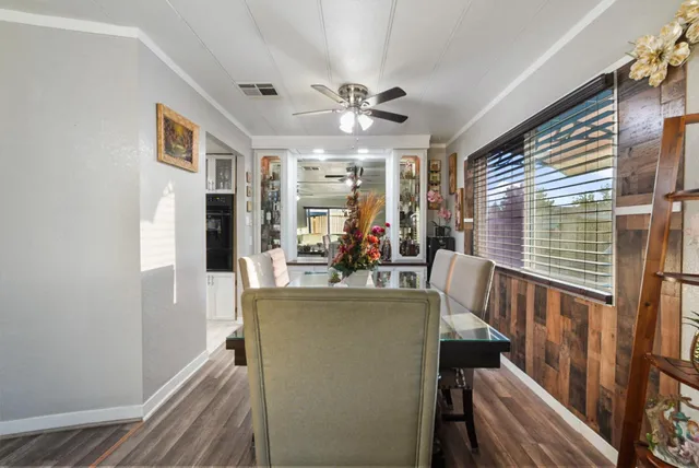 a kitchen with stainless steel appliances granite countertop a refrigerator a microwave oven a sink dishwasher and white cabinets with wooden floor