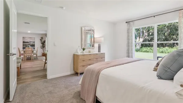 a bedroom with a bed and a large window