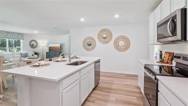 a kitchen with a sink and a stove with wooden floor