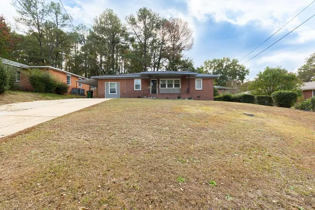 a front view of a house with yard and trees