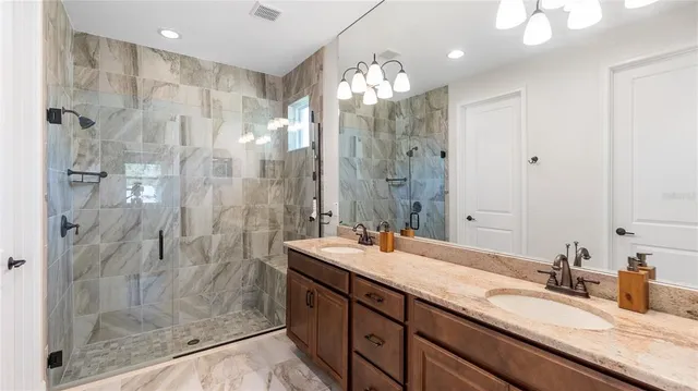 a bathroom with a granite countertop sink a shower and a mirror
