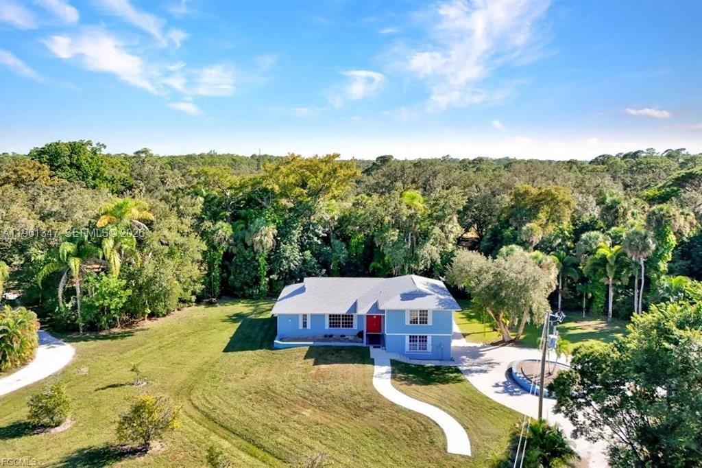 1345 Barrett Road North Fort Myers, FL 33903 - Photo 7 of 27 a view of a house with a big yard and large trees