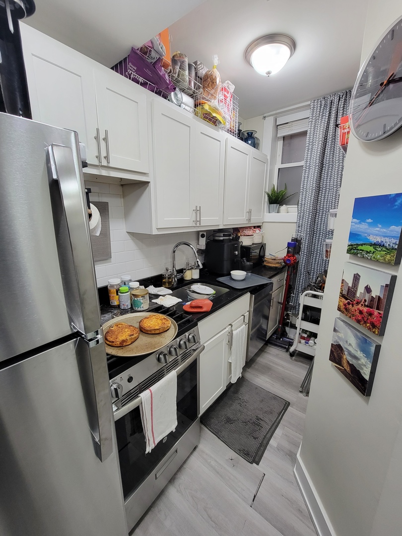648 West Roscoe Street, Unit NGD Chicago, IL 60657 - Photo 4 of 5 a kitchen with stainless steel appliances granite countertop a stove a sink and a refrigerator