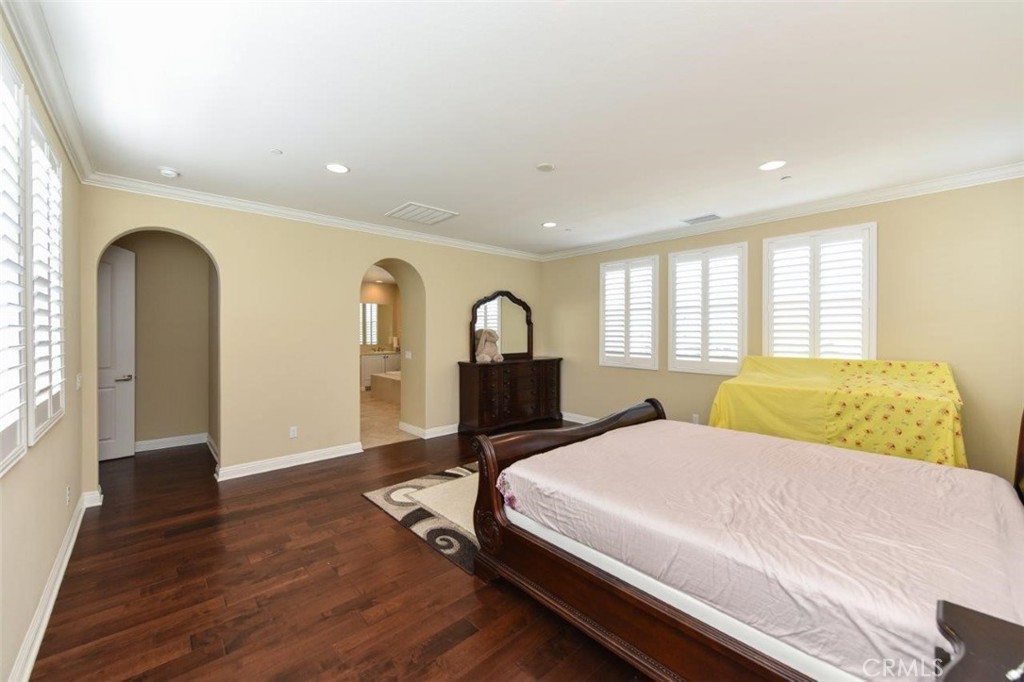 107 Fairgrove Irvine, CA 92618 - Photo 16 of 31 a bedroom with a large bed and wooden floor