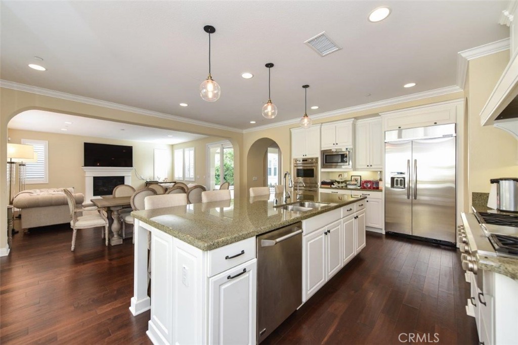 107 Fairgrove Irvine, CA 92618 - Photo 9 of 31 a large kitchen with kitchen island a large counter space a sink appliances and a living room view