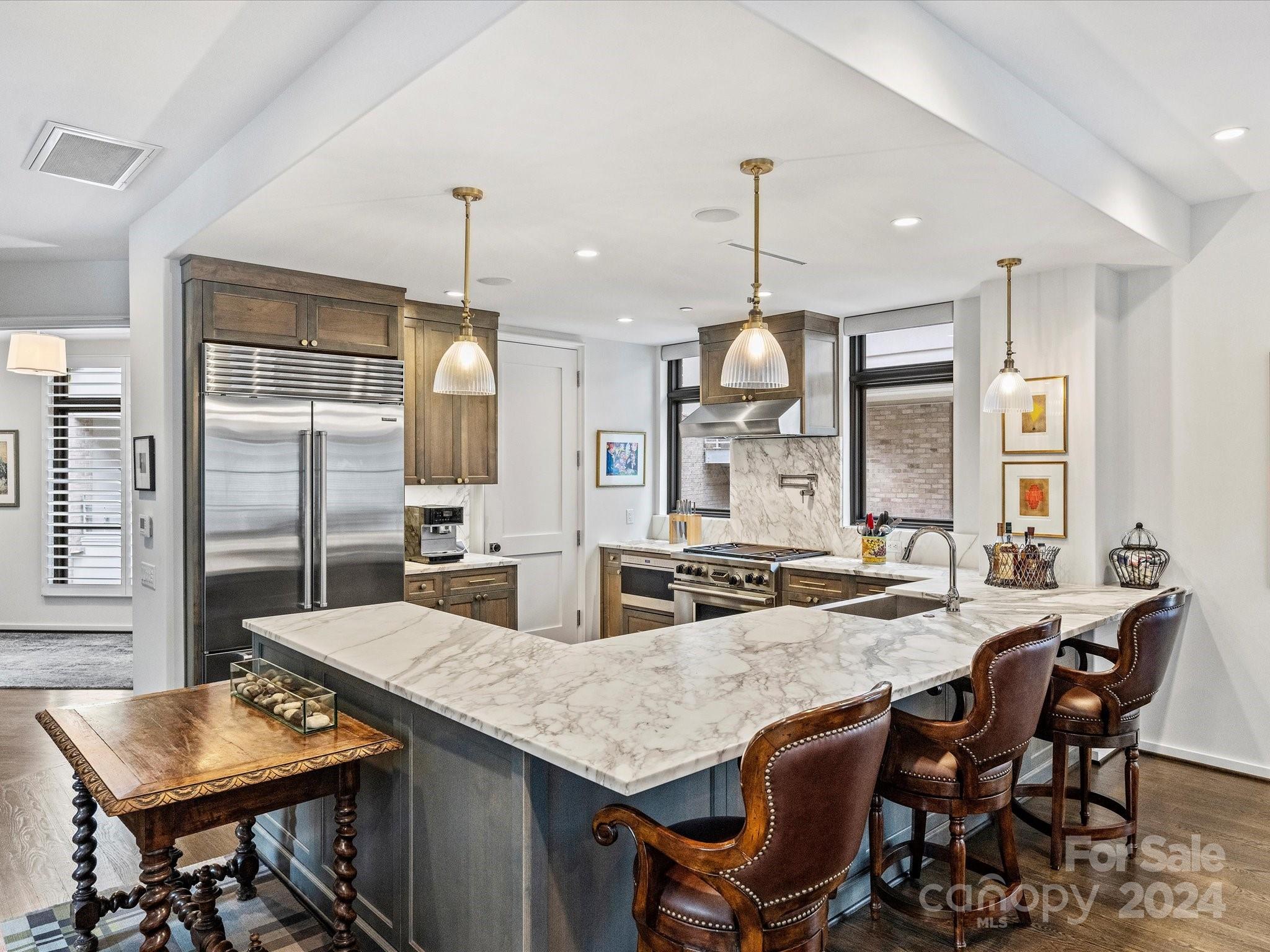 1333 Queens Road, Unit E3 Charlotte, NC 28207 - Photo 13 of 42 a kitchen with granite countertop kitchen island stainless steel appliances and wooden cabinets