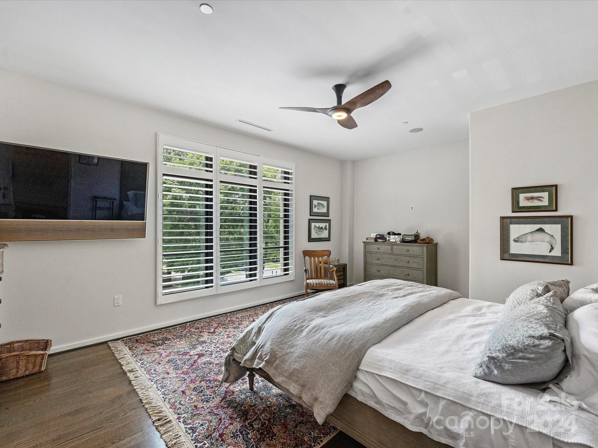1333 Queens Road, Unit E3 Charlotte, NC 28207 - Photo 27 of 42 a bedroom with a large bed and a flat tv screen on dresser