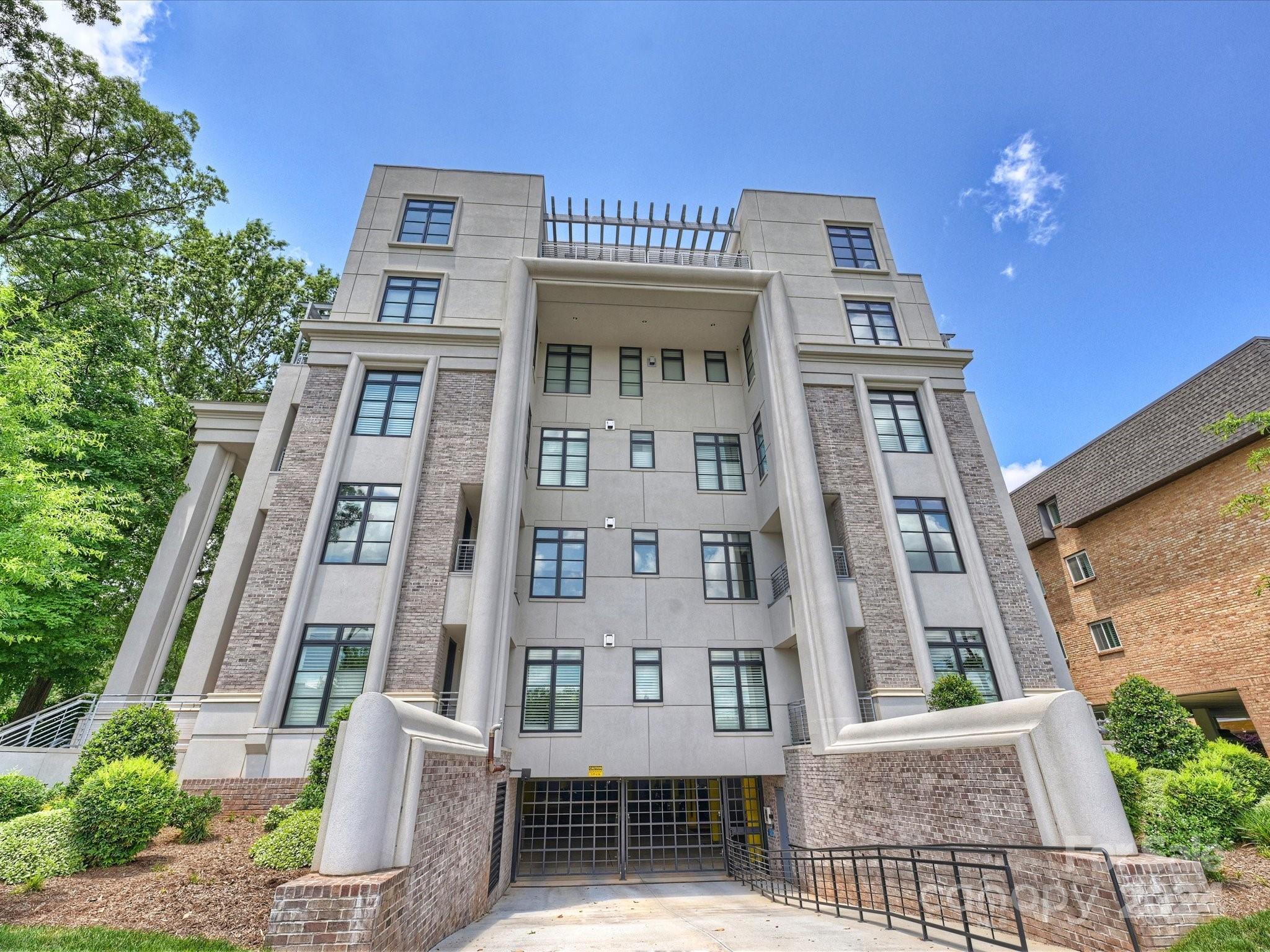 1333 Queens Road, Unit E3 Charlotte, NC 28207 - Photo 3 of 42 a front view of a building with a yard