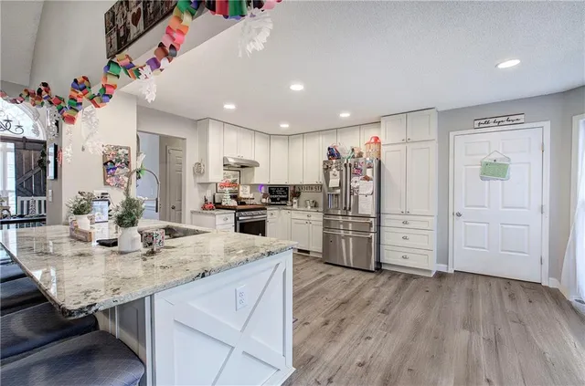a kitchen with refrigerator and cabinets