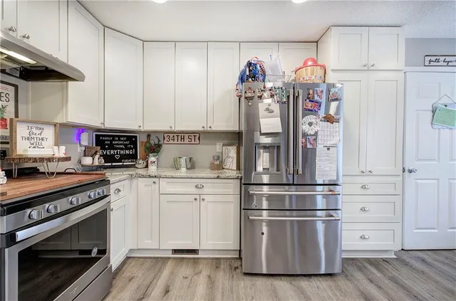 a kitchen with white cabinets and stainless steel appliances