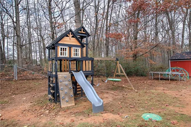 a backyard of a house with a small barn and wooden fence
