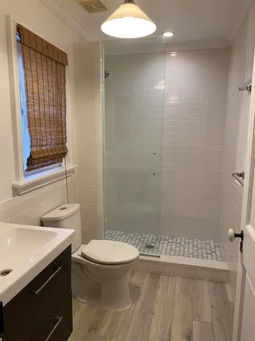 a bathroom with a sink a toilet and shower