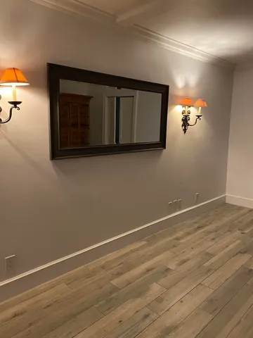 a view of a livingroom with an empty space wooden floor and window