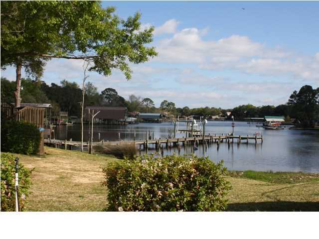 210 Pelham Road, Unit A207 Fort Walton Beach, FL 32547 - Photo 1 of 10 a swimming pool with outdoor seating and lake view