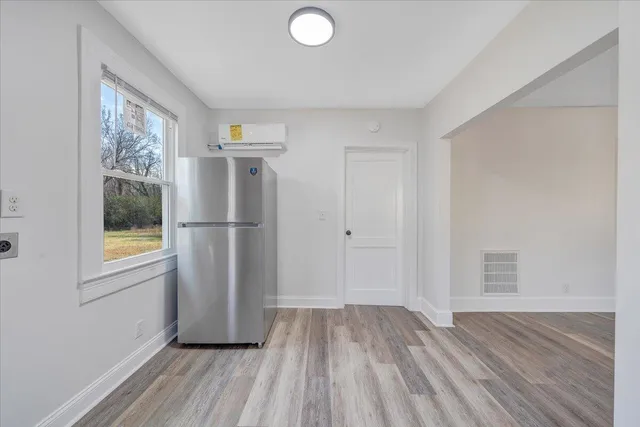 a view of a kitchen with wooden floor and window