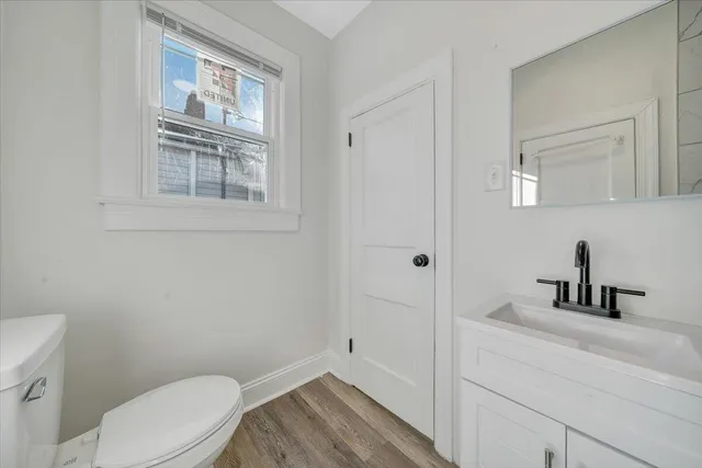 a bathroom with a toilet a sink a vanity and mirror