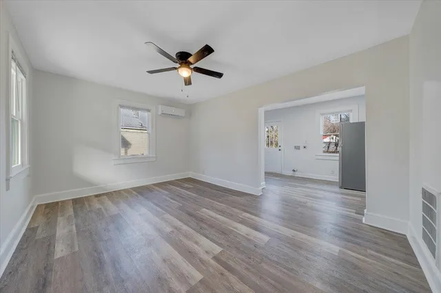 a view of empty room with wooden floor and window