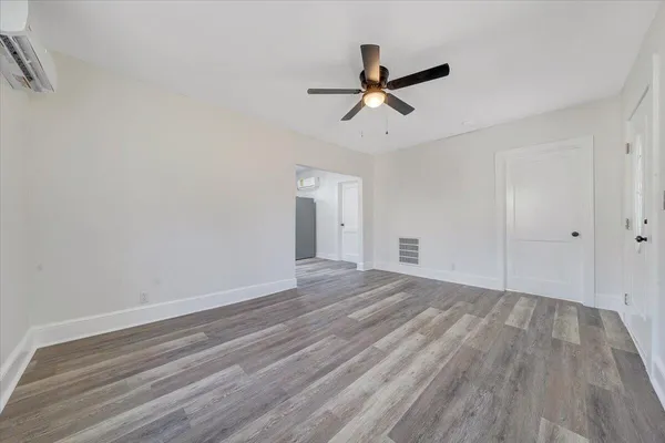 a view of a room with wooden floor and white walls