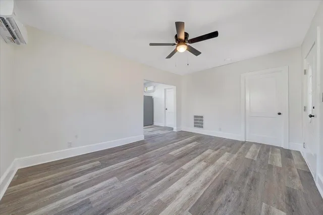 a view of a room with wooden floor and white walls