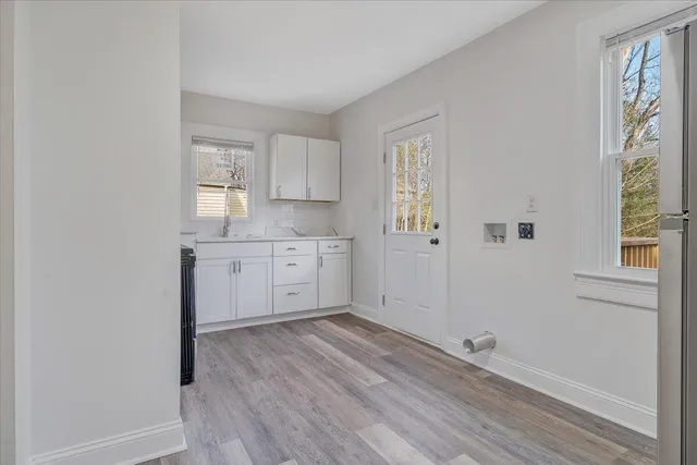 a view of a kitchen with wooden floor and electronic appliances