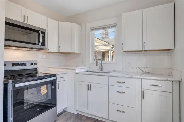 a kitchen with white cabinets and appliances