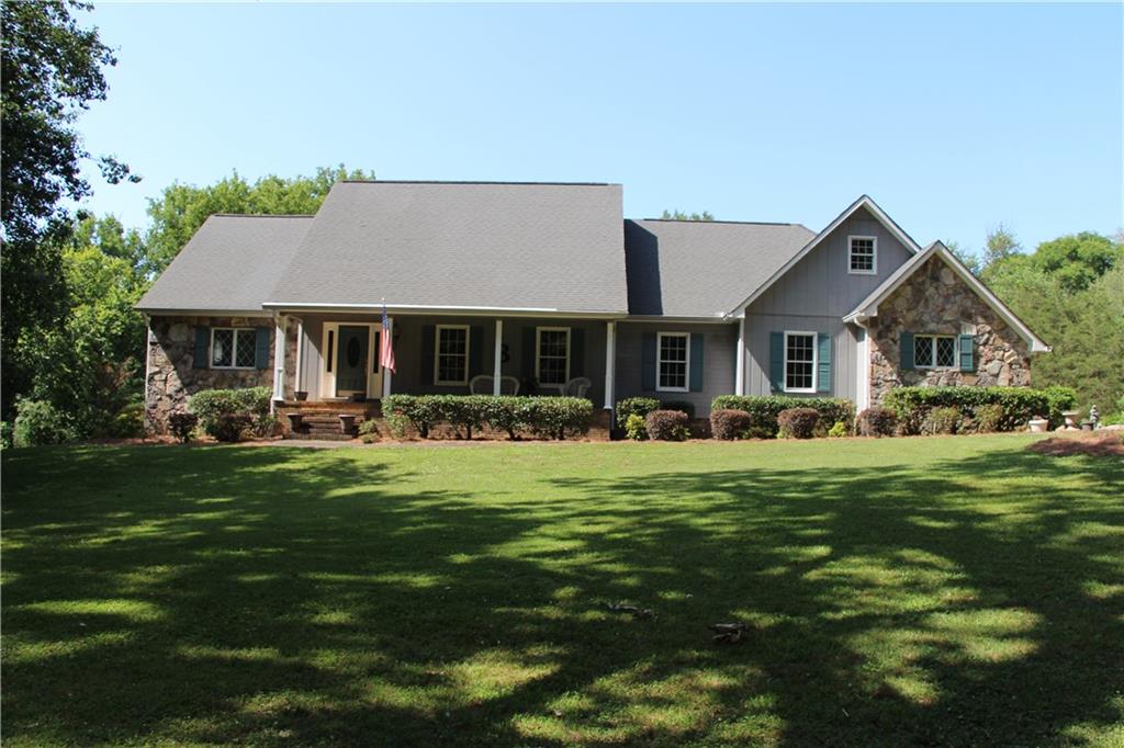 129 Tate Estates Road Southeast Rome, GA 30161 - Photo 1 of 1 a front view of a house with a garden and trees