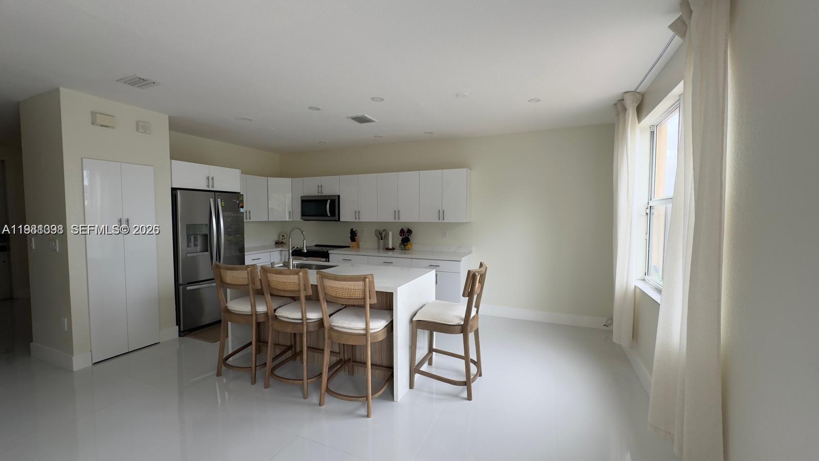 949 Northeast 42nd Avenue Homestead, FL 33033 - Photo 4 of 17 a view of a dining room with furniture and a refrigerator