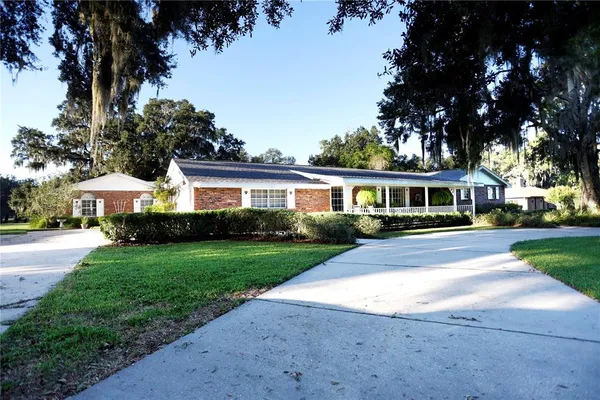 a front view of a house with a garden and trees
