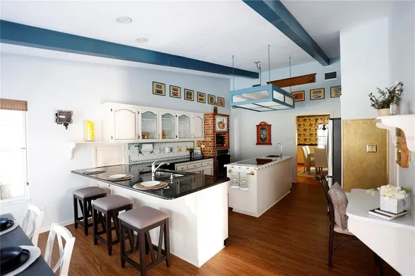 a living room with lots of furniture and a dining table with wooden floor