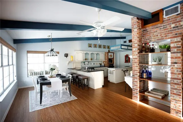 a dining room with wooden floor and a chandelier