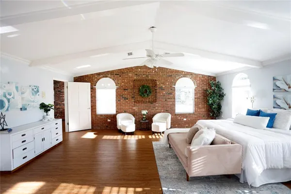 a living room with furniture a chandelier and a wooden floor