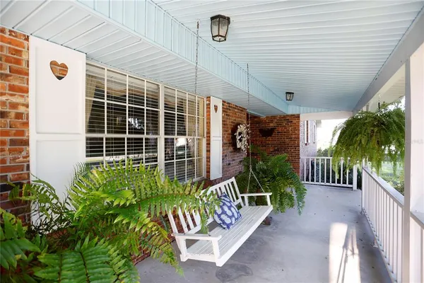 a porch with a bench next to a yard