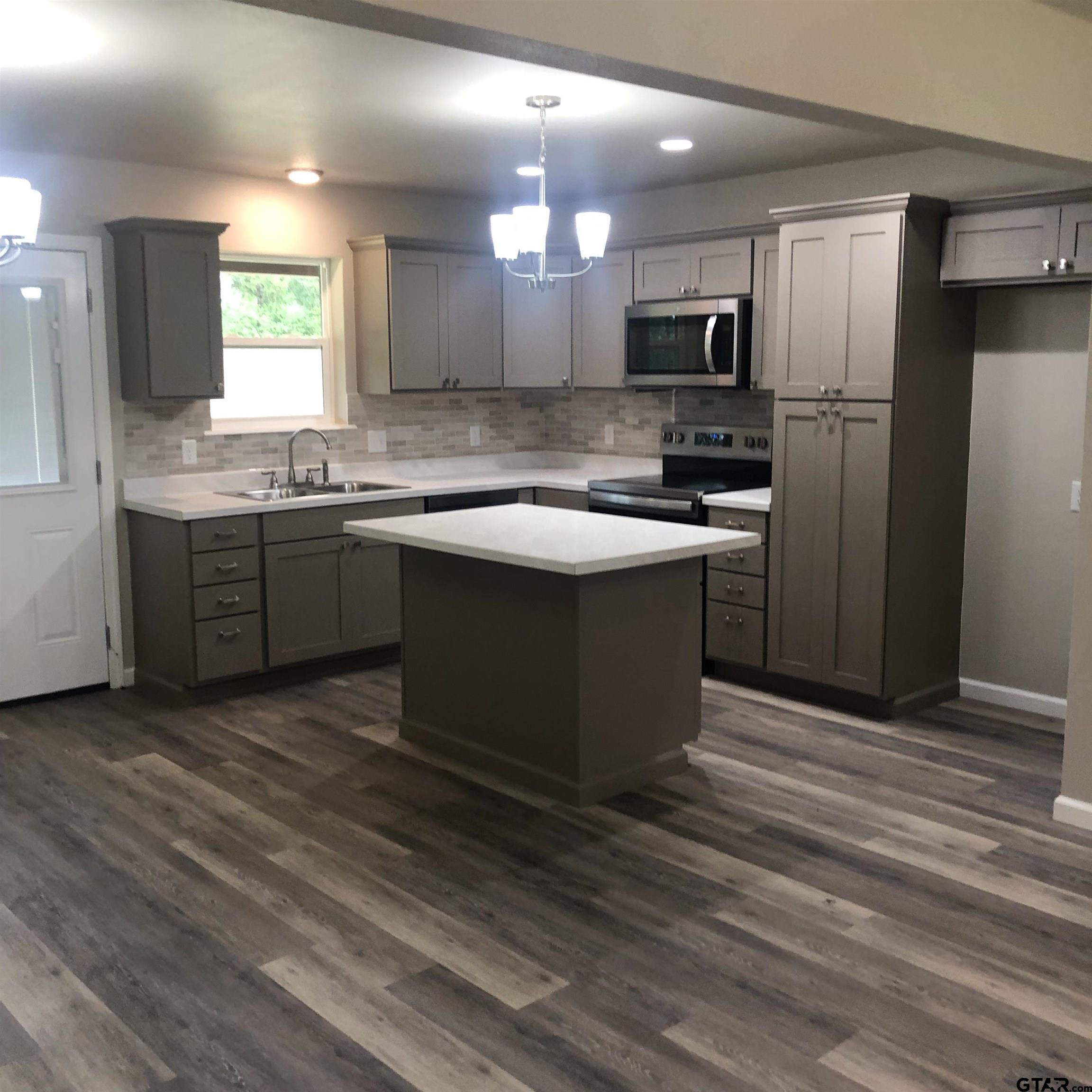 105 Meadows Lane Maud, TX 75567 - Photo 4 of 19 a kitchen with kitchen island granite countertop a sink stove and refrigerator
