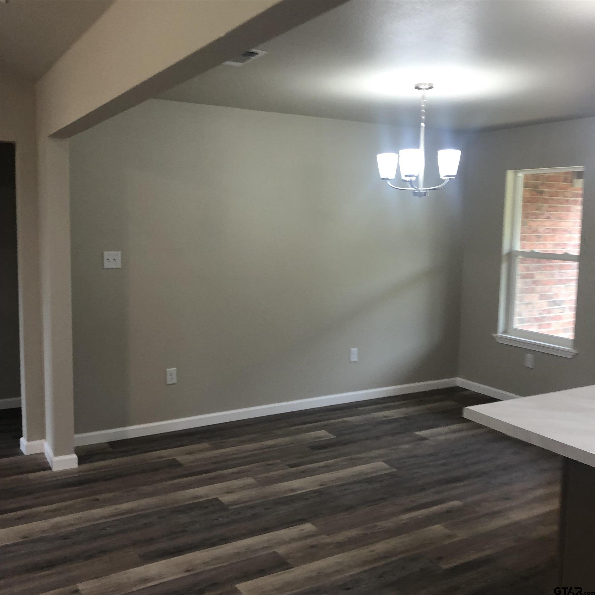 105 Meadows Lane Maud, TX 75567 - Photo 5 of 19 an empty room with wooden floor and windows