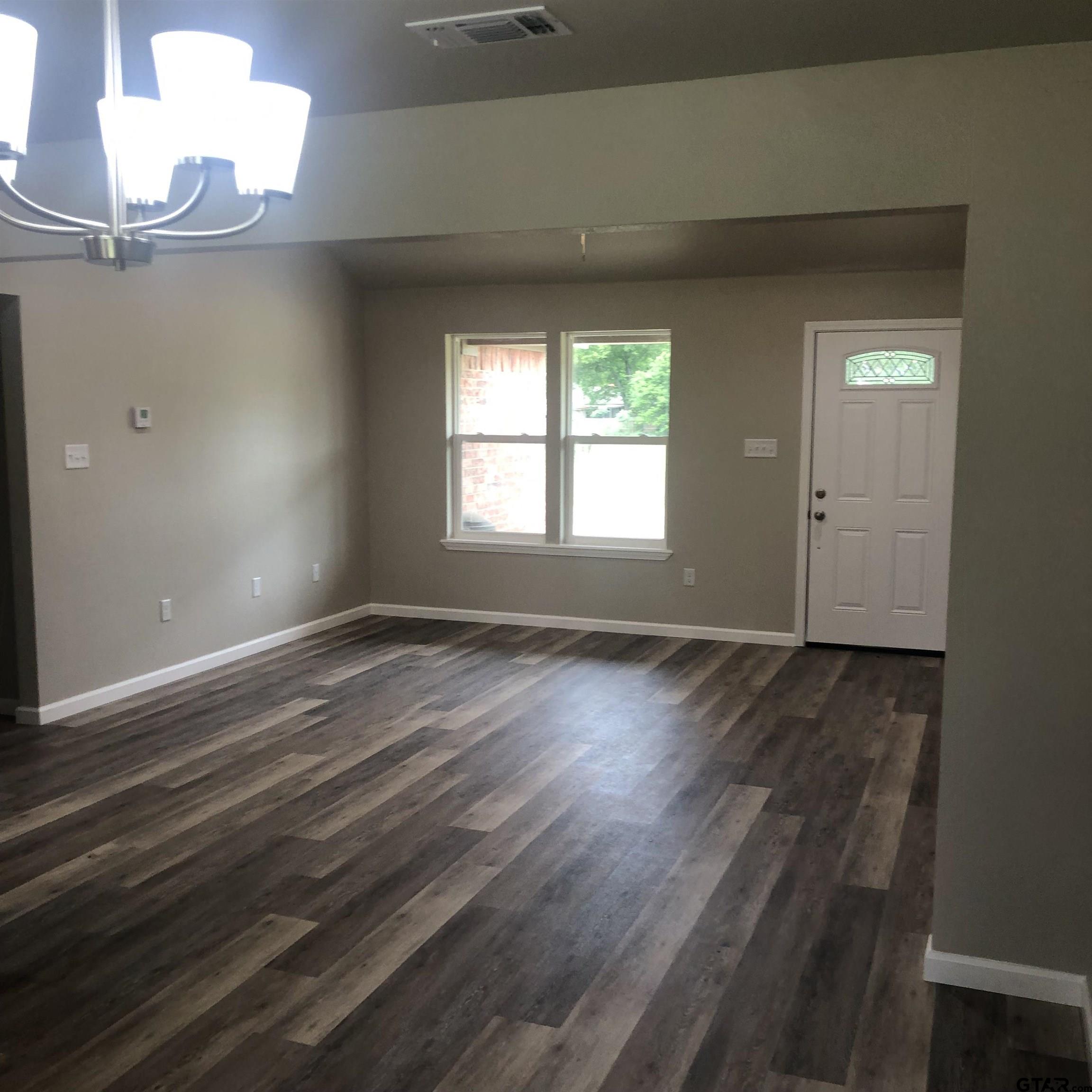 105 Meadows Lane Maud, TX 75567 - Photo 6 of 19 an empty room with wooden floor and windows