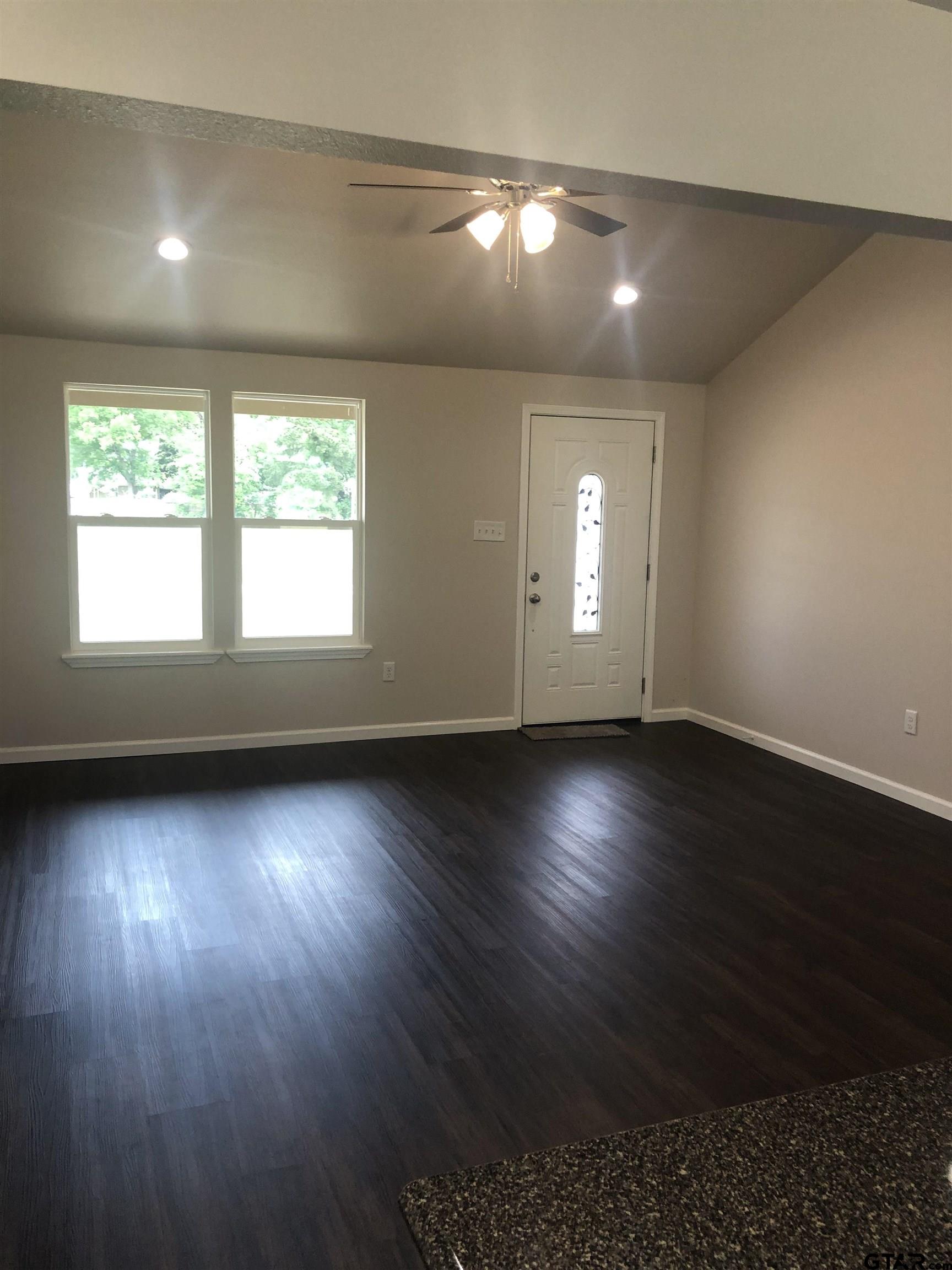 105 Meadows Lane Maud, TX 75567 - Photo 6 of 19 an empty room with wooden floor and windows