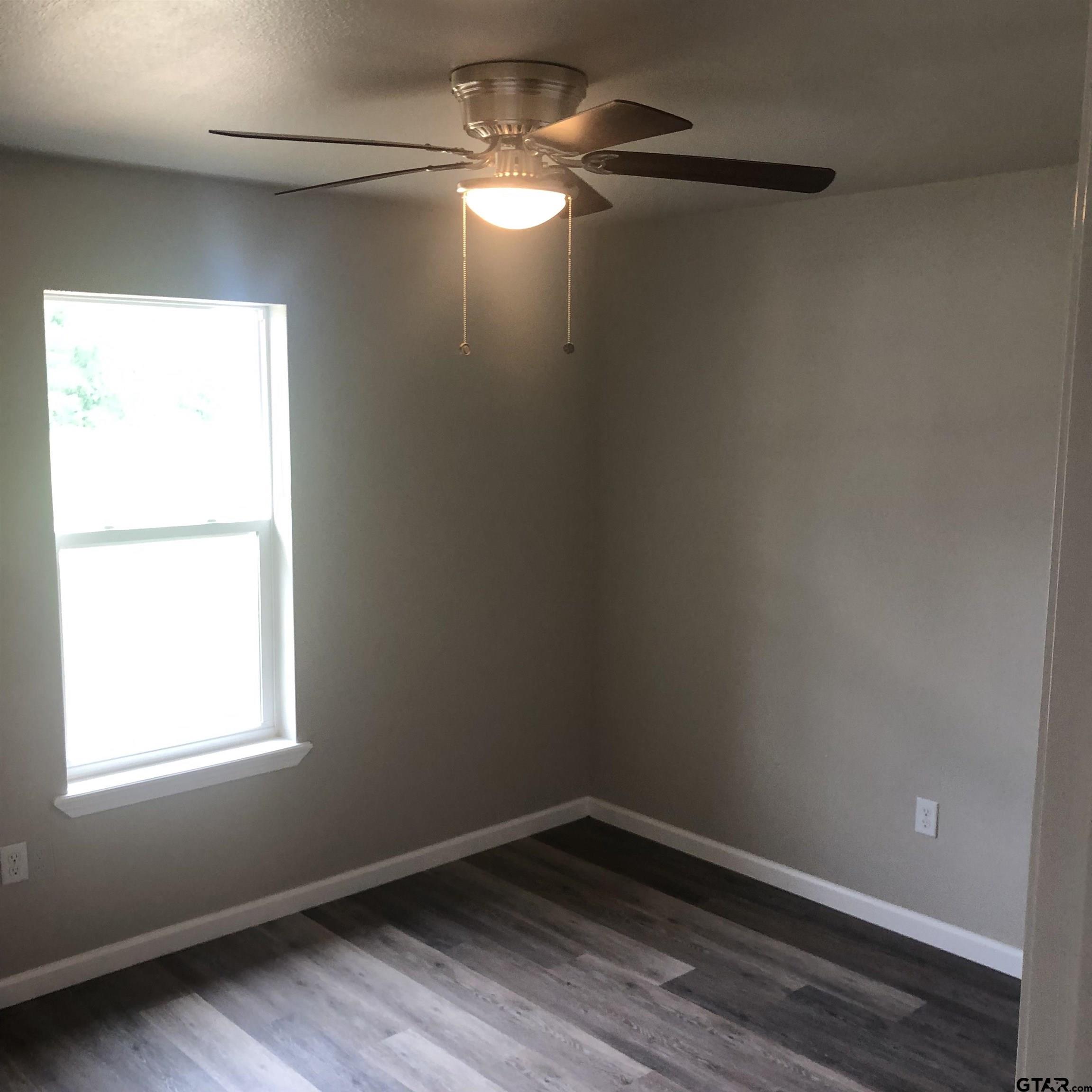 105 Meadows Lane Maud, TX 75567 - Photo 7 of 19 wooden floor in an empty room with a window