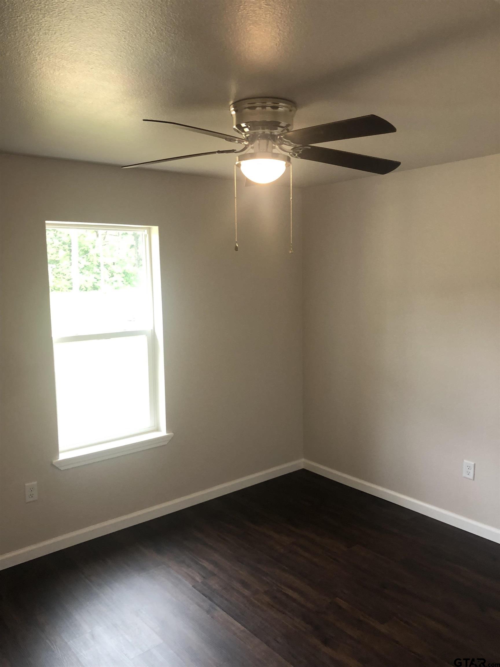 105 Meadows Lane Maud, TX 75567 - Photo 7 of 19 a view of an empty room with wooden floor and a window