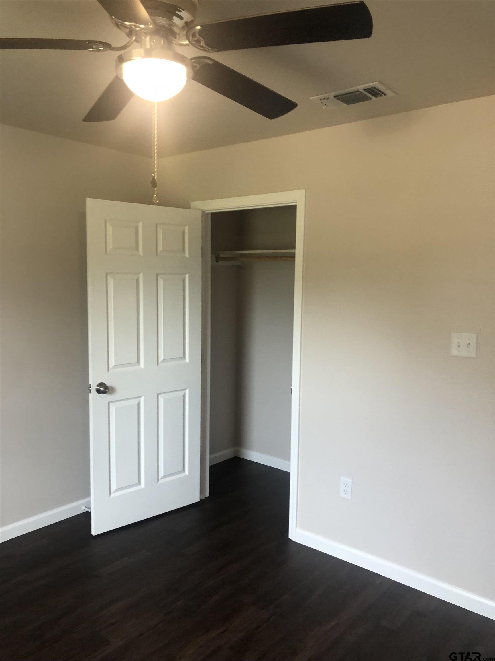 105 Meadows Lane Maud, TX 75567 - Photo 8 of 19 an empty room with wooden floor fan and windows