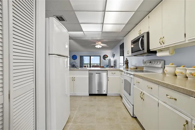 a kitchen with white cabinets and white appliances