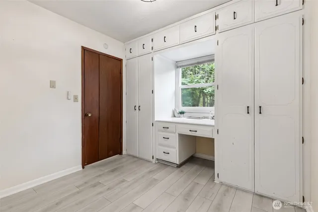 a view of an empty room with window and cabinet