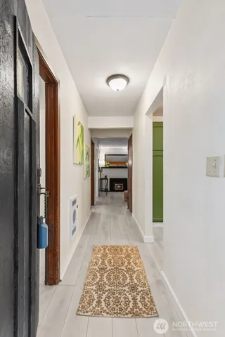 a view of a hallway with wooden floor and a living room